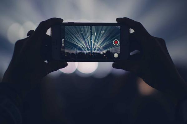 Person recording concert on phone