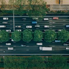 Cars moving on a two way road divided by a strip of trees in the middle